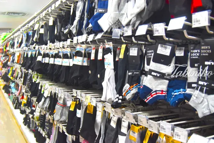 Aisle filled with various men’s socks displayed on hooks in a DIY store.