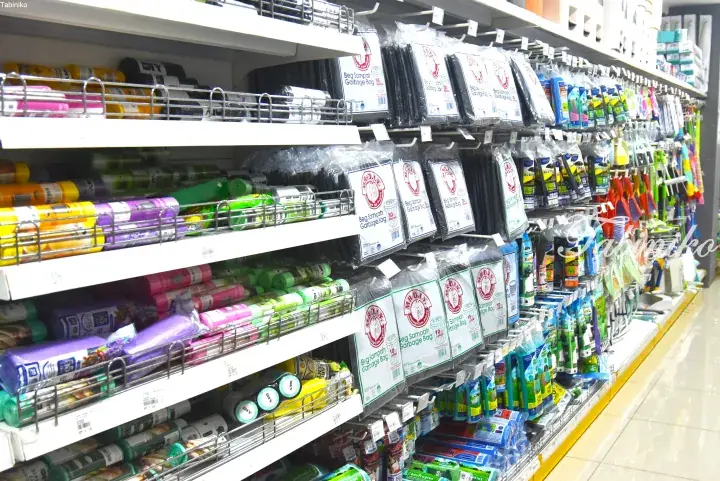 Shelves stocked with colorful garbage bags and cleaning supplies at a Mr. DIY store in Malaysia.