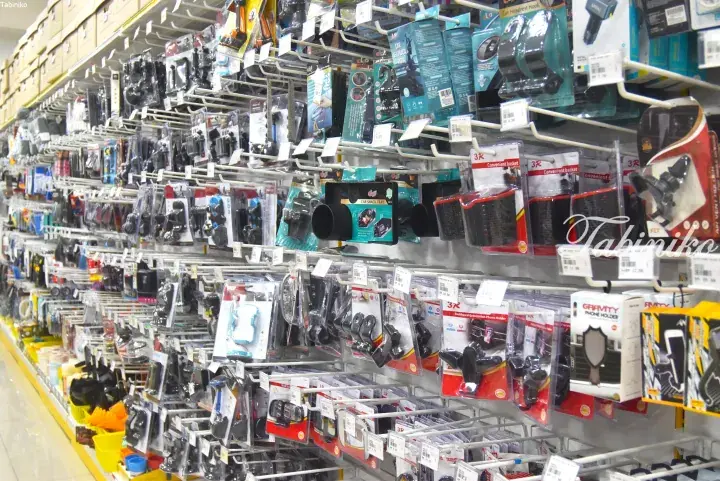 Aisle filled with various car accessories like phone holders and hooks at a Malaysian retail store.