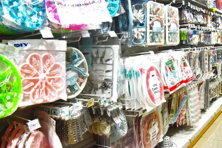 A display of colorful circular clothes hangers with clips and metal clips hanging on a store rack.