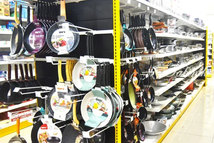 Shelves stocked with various frying pans and cookware at a MR.DIY store in Malaysia.