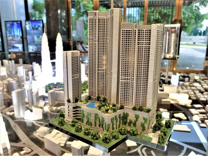 Architectural model of a modern high-rise residential complex with landscaped gardens and surrounding cityscape.