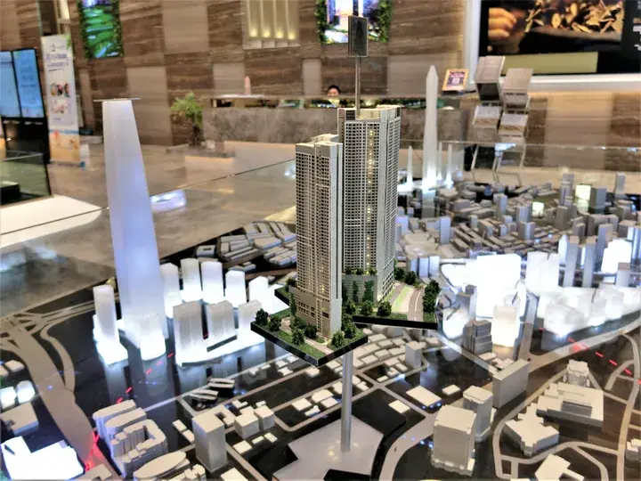 Architectural scale model of a modern high-rise residential tower surrounded by a detailed cityscape layout.