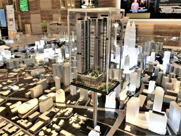 Architectural model of a high-rise residential tower surrounded by a detailed cityscape display.