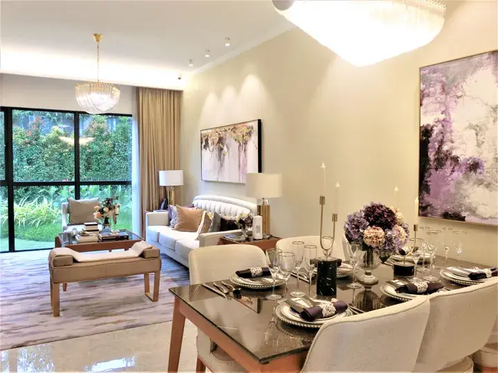 Modern luxury dining and living room with elegant table setting, white sofa, and large windows overlooking a lush garden.