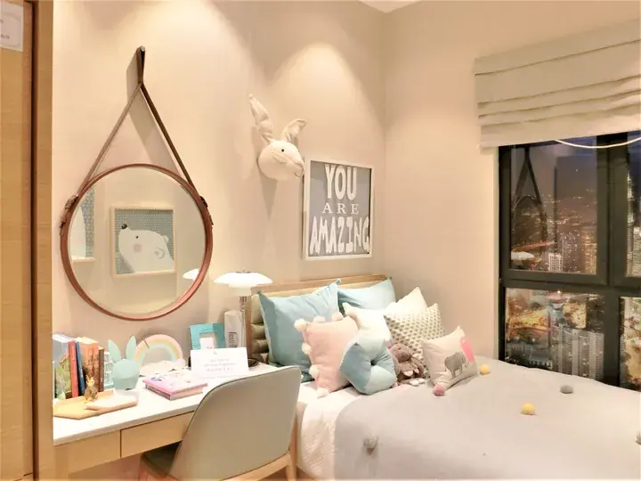 Cozy bedroom with a bed, desk, and city view, featuring a round mirror and &lsquo;You Are Amazing&rsquo; wall art.