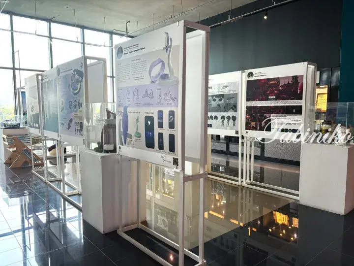 Modern exhibition displays featuring product designs and digital interfaces in a bright, polished showroom.