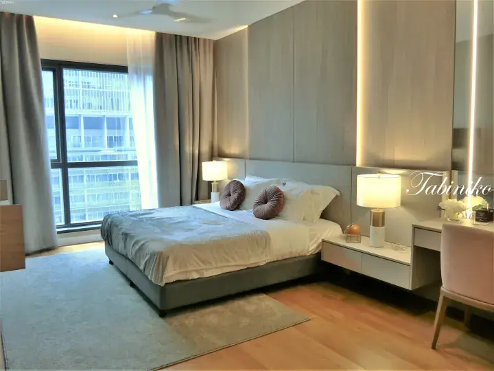 Modern hotel bedroom with a king bed, city view, and warm ambient lighting.