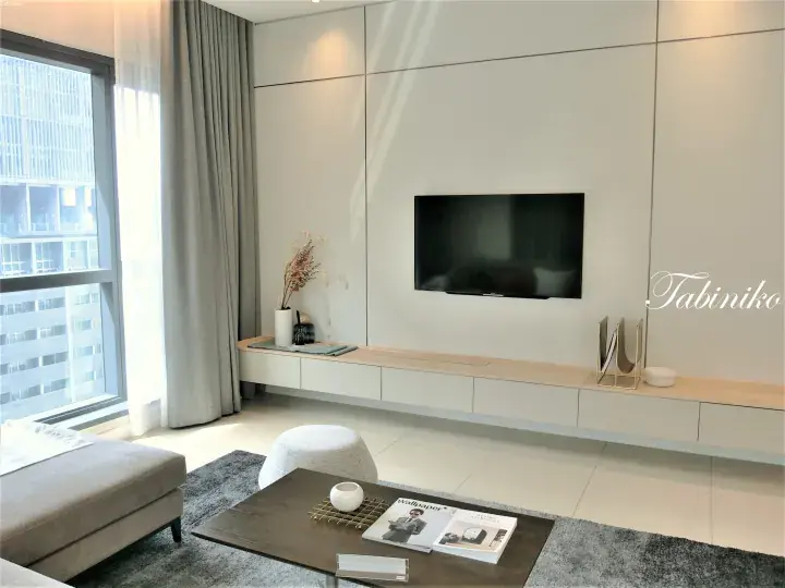 Modern minimalist living room with floor-to-ceiling window, white wall unit, and wooden TV console.