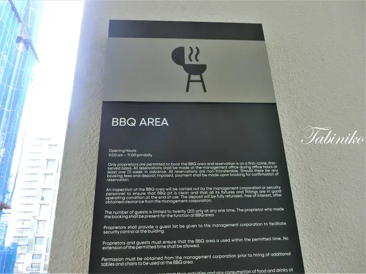 BBQ area sign with rules and opening hours at a Malaysian property.