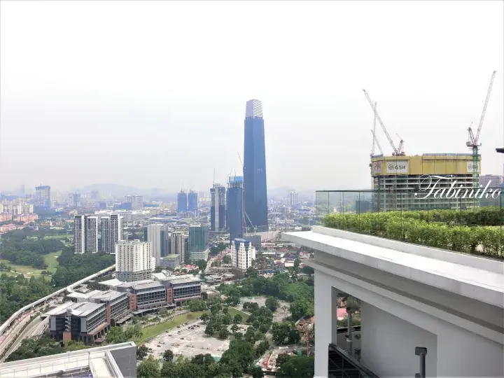 Kuala Lumpur cityscape view featuring Merdeka 118 tower and construction site from a rooftop terrace.