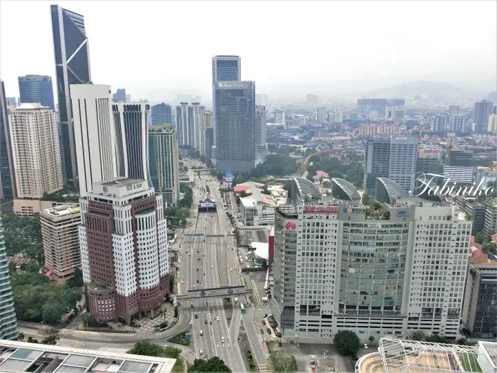 Kuala Lumpur cityscape view featuring the iconic Menara Maybank tower and bustling Jalan Tun Razak.