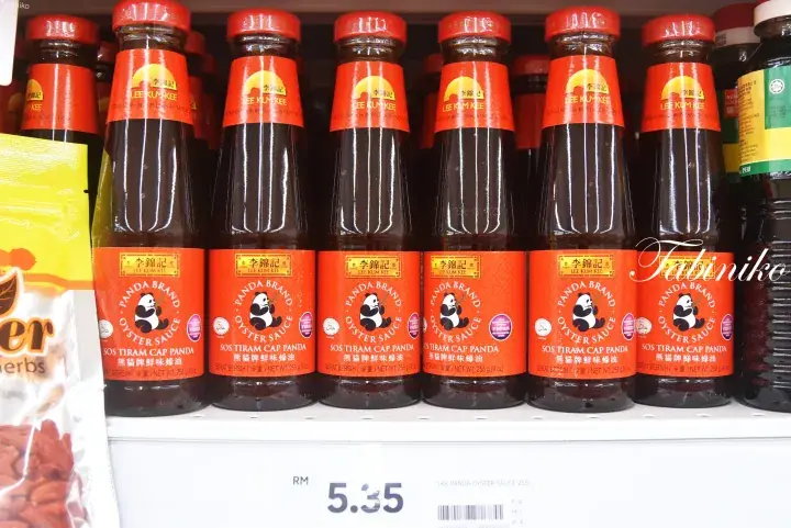 Bottles of Panda Brand oyster sauce on a supermarket shelf with a price tag of RM 5.35.