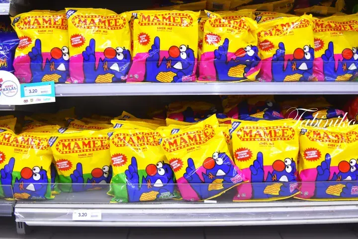 Yellow and blue Mamee Monster snack packets displayed on supermarket shelves with price tags.
