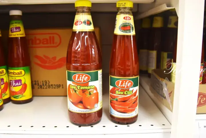 Life brand tomato and chili sauces on a grocery shelf alongside other condiments.