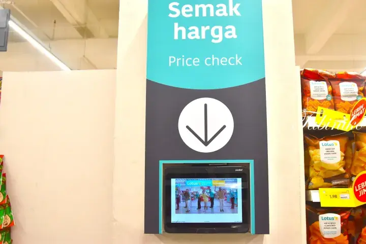 Price check kiosk with Semak harga sign and touchscreen display at Lotus’s supermarket in Malaysia.