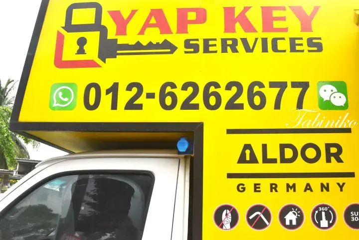 Yellow service van for Yap Key Services displaying contact number, Tabiniko, Aldor Germany, and lock icons.