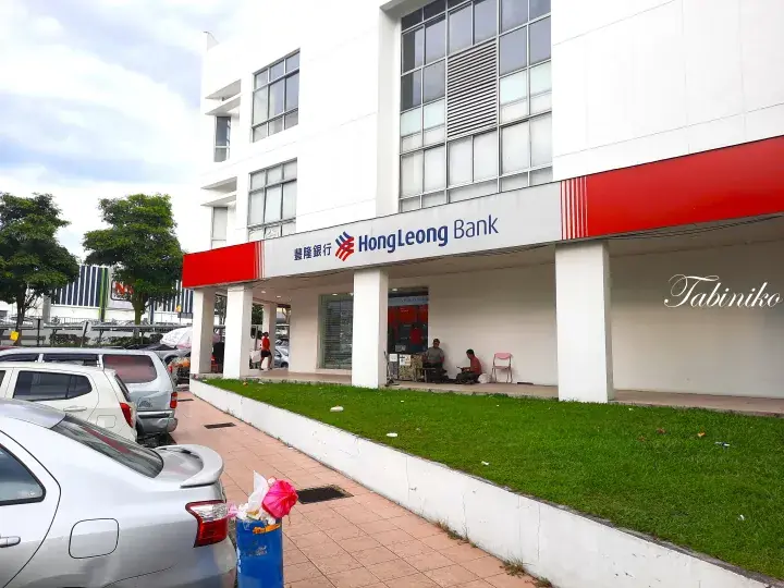 Hong Leong Bank branch exterior with customers sitting under the covered walkway in Malaysia