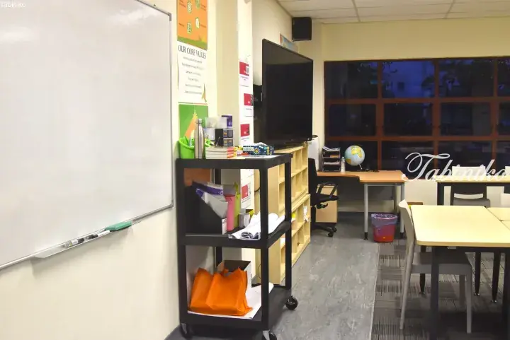 Bright classroom interior with whiteboard, TV, and student desks at a Malaysia language centre.