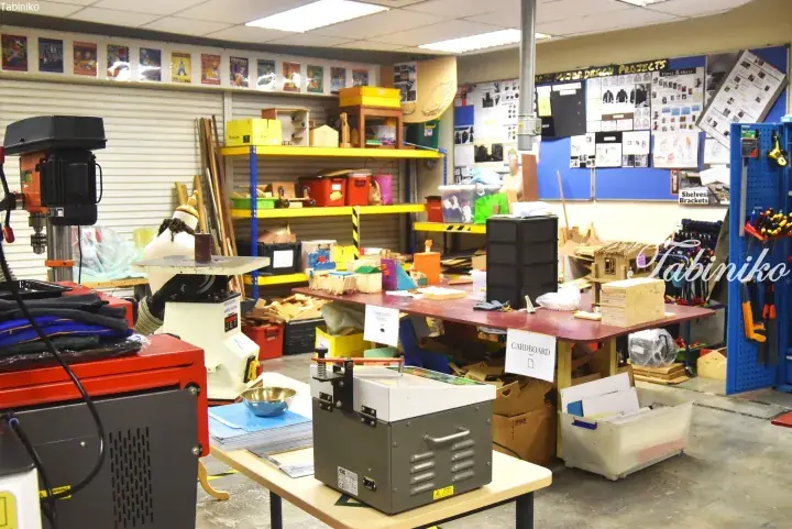 A well-organized workshop with tools, workbenches, and storage shelves in a creative studio space.