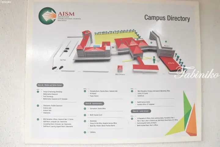 A campus directory sign at AISM Malaysia showing a 3D map and room listings for the Middle and Senior School blocks.