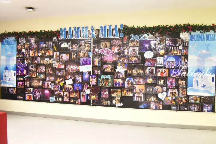 Mamma Mia! 2022 musical commemorative wall display featuring numerous photos and decorations.