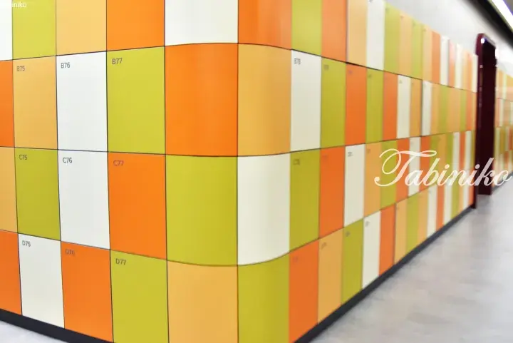 Colorful geometric lockers in a modern hallway with orange, green, and white panels.