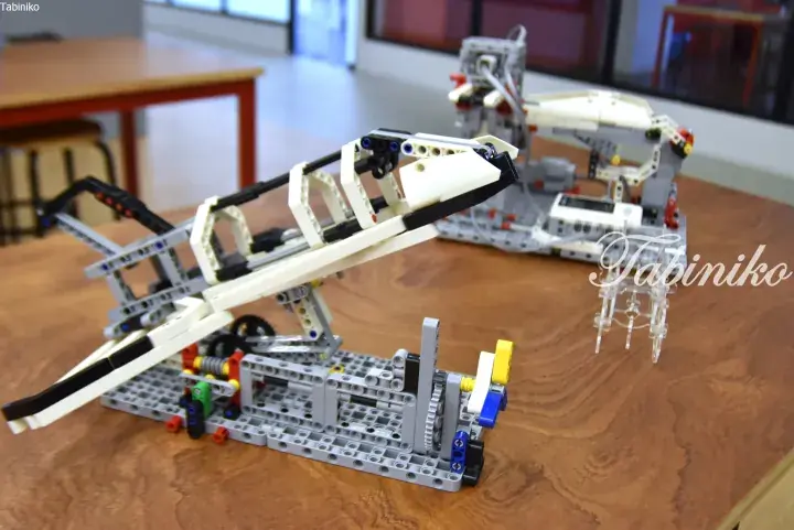Detailed LEGO Technic model of a futuristic aircraft on a wooden table.