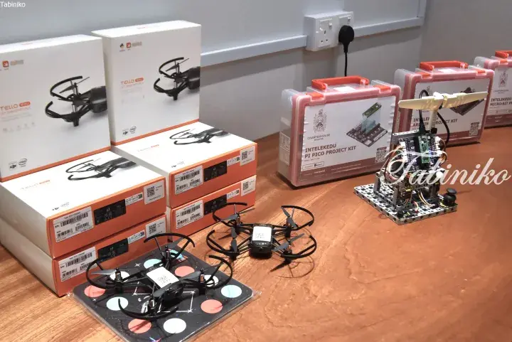 Stacks of DJI Tello EDU drone boxes and an IntelekEdu Pi Pico project kit displayed on a wooden table.