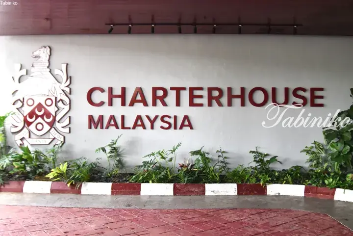 Charterhouse Malaysia entrance sign with red lettering and crest on a white wall.