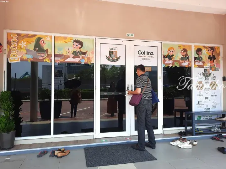 Man entering Collinz International School office at B2-G-03A, with shoes removed outside.