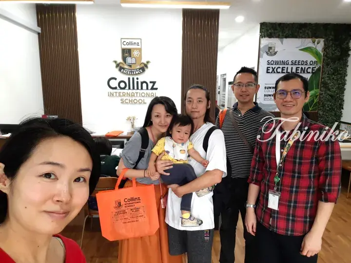 Family visiting Collinz International School in Malaysia, holding a branded tote bag at the reception area.