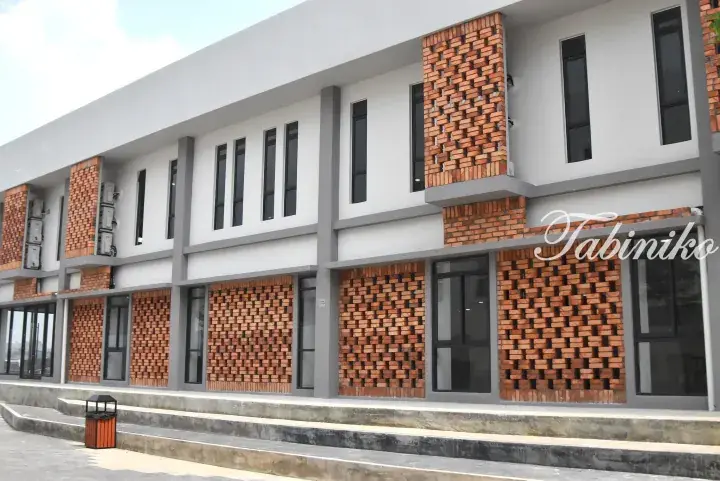 Modern two-story building with white facade, grey accents, and decorative red brick lattice patterns on the exterior walls.