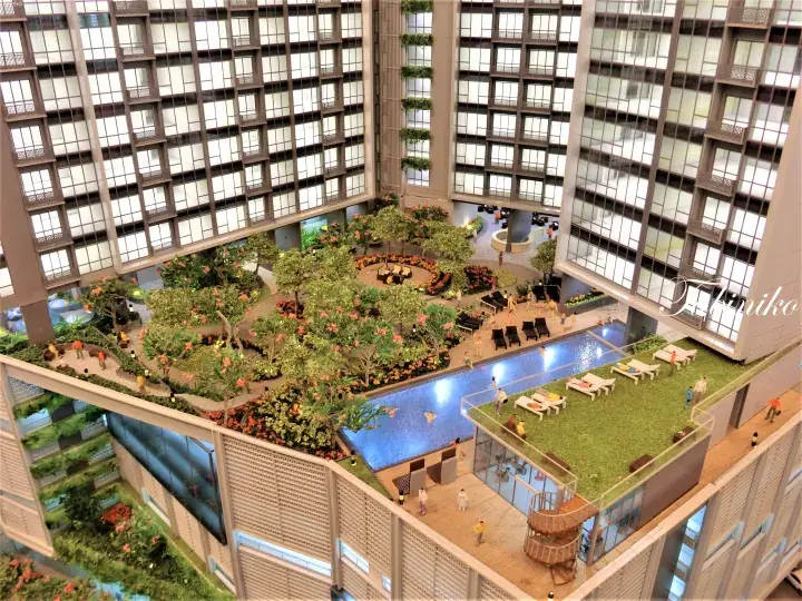 Architectural model showing a luxury high-rise with lush sky gardens, swimming pool, and lounge areas.