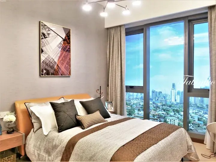 Modern bedroom with city skyline view through floor-to-ceiling windows in a Kuala Lumpur property.