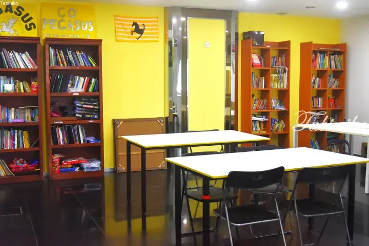 Bright yellow study room with bookshelves, tables, and Pegasus wall art in a Malaysian property.