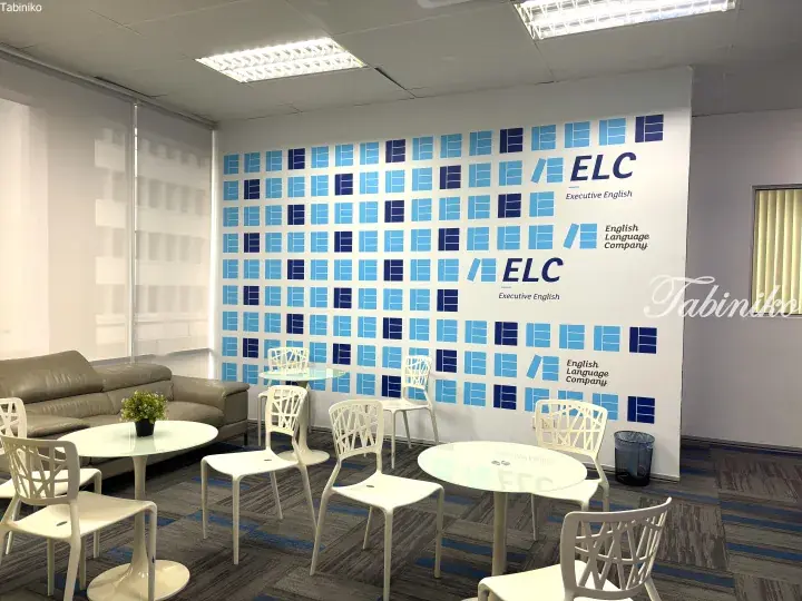 Modern lounge area with white chairs and tables at English Language Company ELC Executive English training center.
