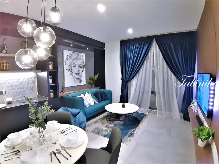 Modern apartment interior with teal sofa, dining table, and blue curtains in Kuala Lumpur.