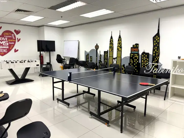 Recreation room with table tennis and foosball at EMS Language Centre featuring city skyline wall art.