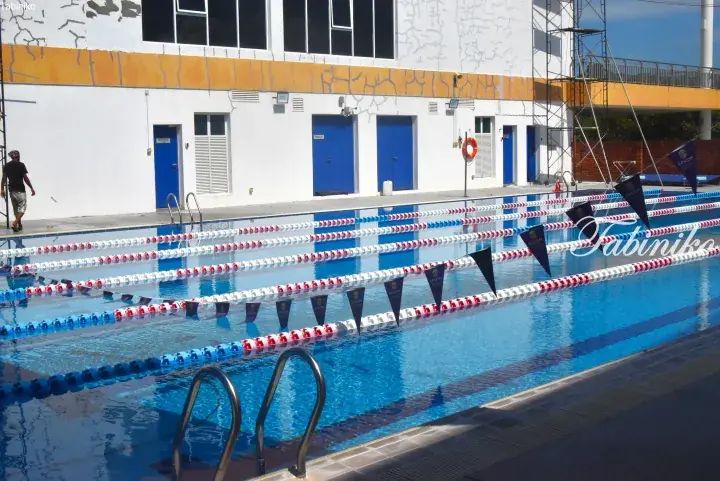 Outdoor swimming pool with lane dividers and blue flags at Epsom College in Malmesbury, Malaysia.