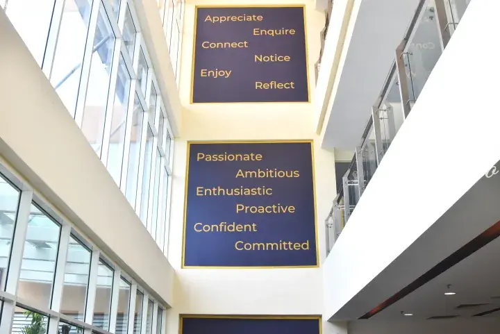 Interior wall displays motivational words like Passionate and Enthusiastic in a modern building atrium.