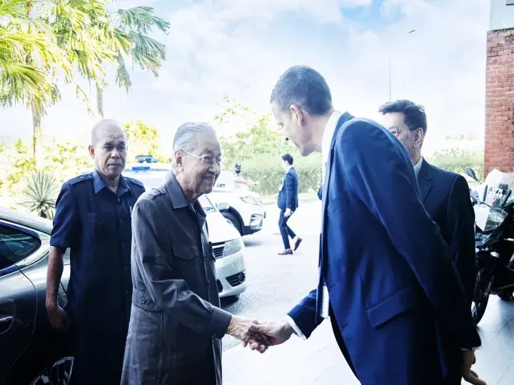 Malaysian Prime Minister Tun Dr. Mahathir Mohamad shaking hands with a foreign dignitary during an official visit.