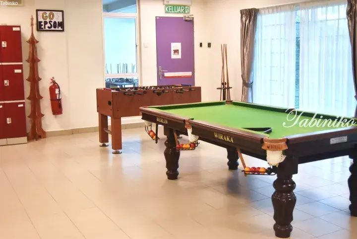 Recreation room with a Wiraka pool table and foosball table near a purple exit door.