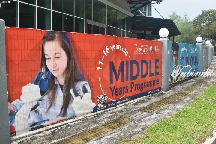 Fairview International School banner advertising Middle Years Programme for ages 11-16, featuring a student using a microscope.