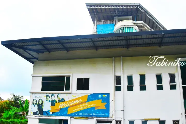 Fairview International School building exterior with a welcome banner and students.