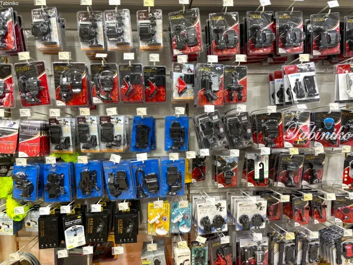 Shelves displaying a wide variety of packaged car phone holders in a store.