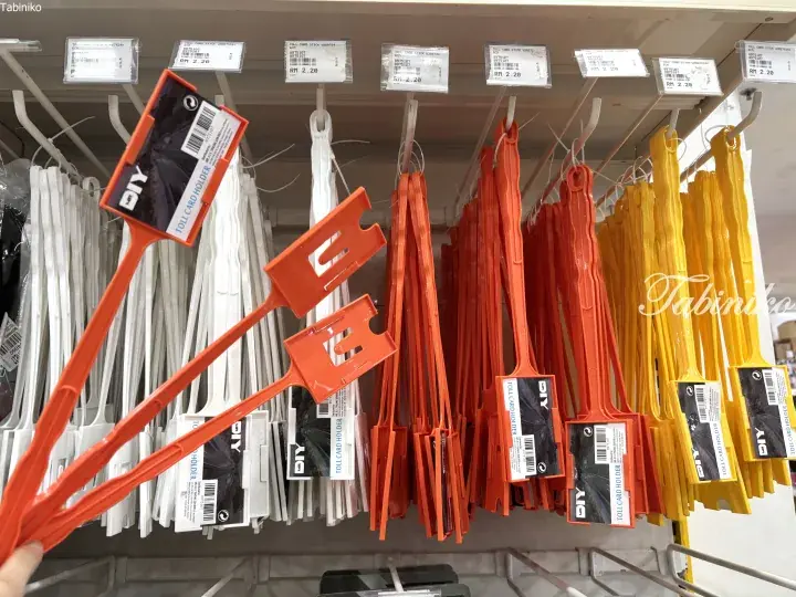 Orange and yellow plastic toll card holders hanging on a store rack with price tags.