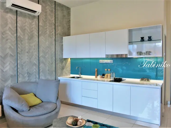 Modern kitchen with white cabinets, teal backsplash, and grey armchair in a stylish apartment