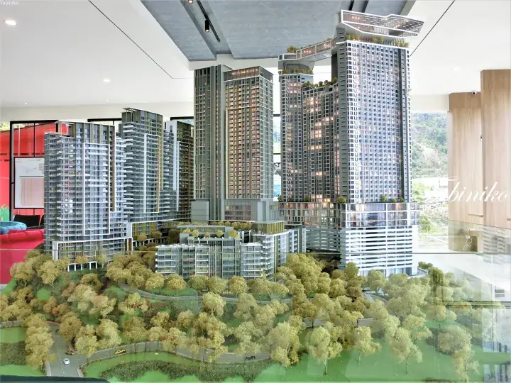 Architectural model of a modern high-rise residential complex with skybridges and lush landscaping.