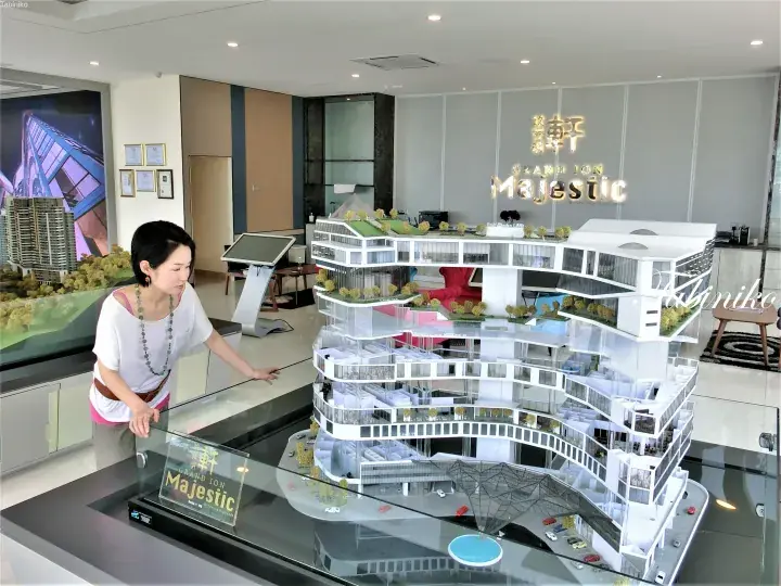 Woman examining architectural model of Grand Ion Majestic at Genting Highlands sales gallery.